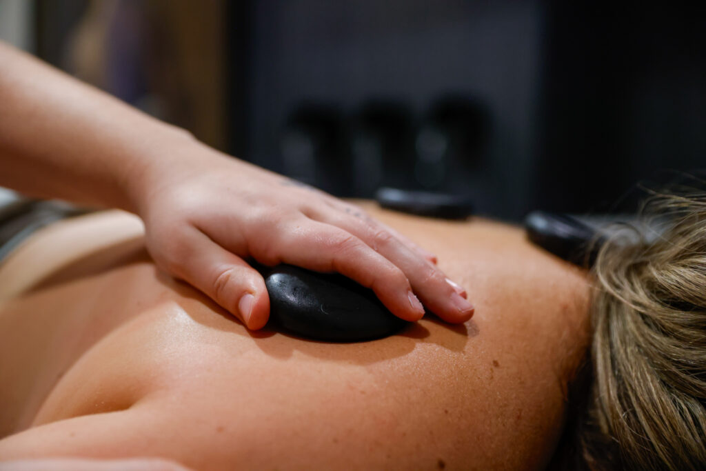 A provider at The Sonography Studio preforming massage therapy on a patient, gently placing warmed stones on the back of a relaxing patieint. In addition to our lactation specialist in Sioux Falls, The Sonography Studio offers a number of treatments that enhance and support your overall wellness. 