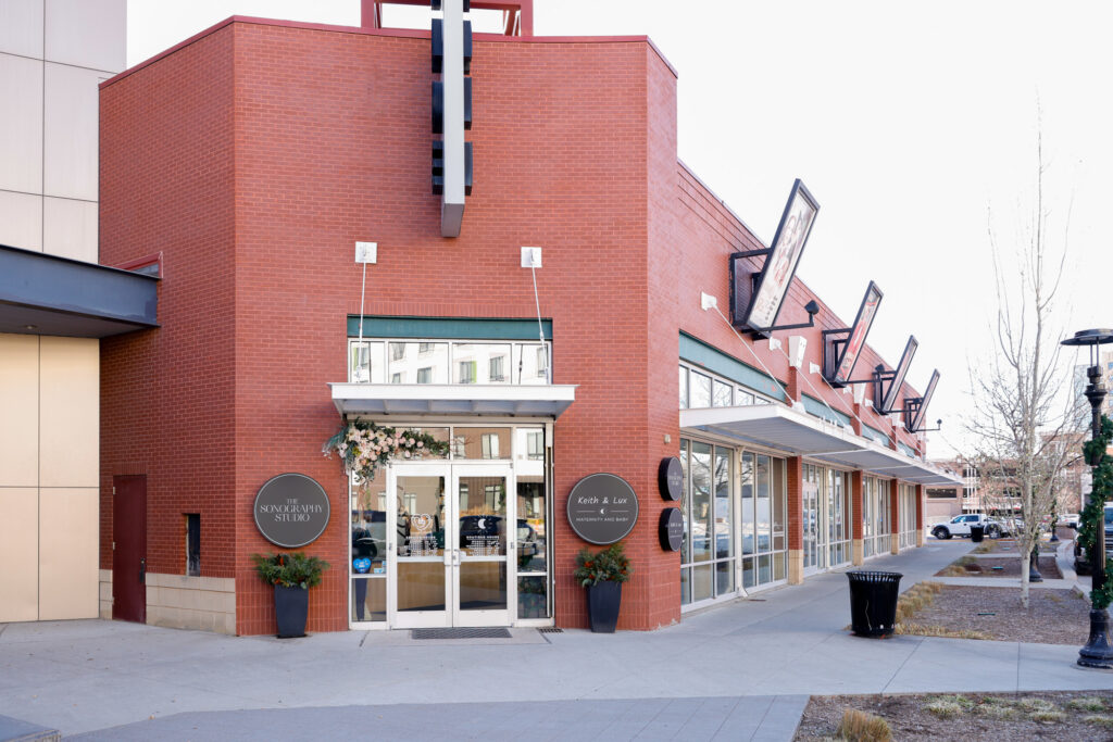 Exterior of The Sonography Studio, a red brick building with double doors.