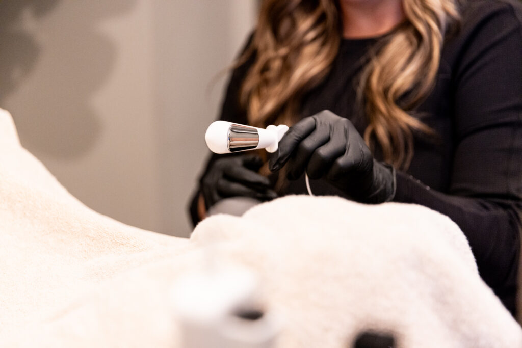 A medical provider holding the VTone device to complement Vaginal Rejuvenation Near Omaha.